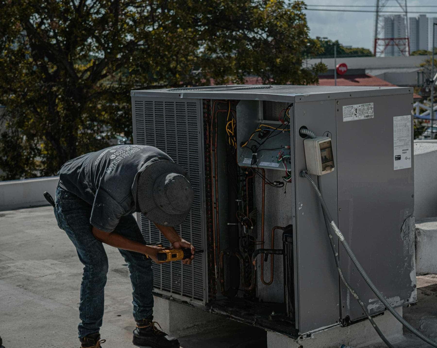Technician repairing rooftop air conditioning equipment